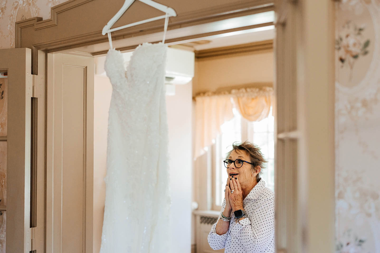 Felt Estate wedding photographer Saugatuck Michigan candid mother overwhelmed with emotion seeing wedding dress hanging in doorway, top West Michigan luxury wedding photography GAUPERphoto