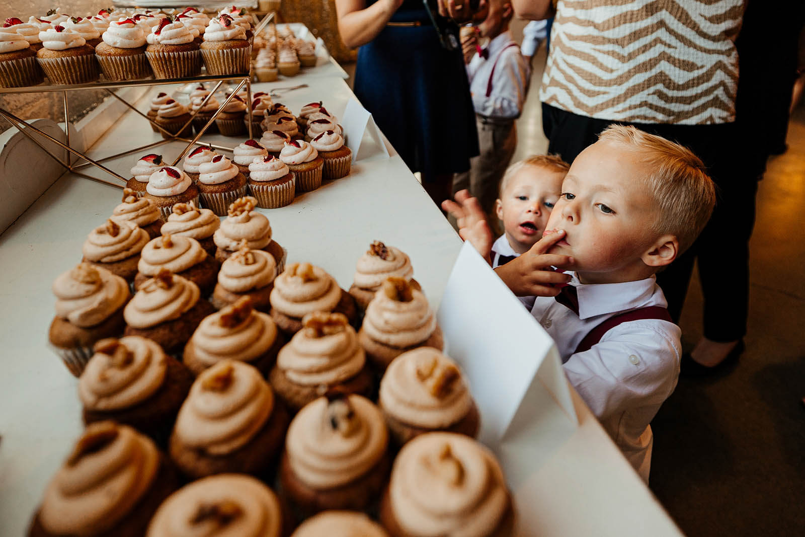 Cheney Place wedding photographer Grand Rapids Michigan unposed kids sneaking cupcakes from dessert table at wedding reception, best candid documentary wedding photography West Michigan