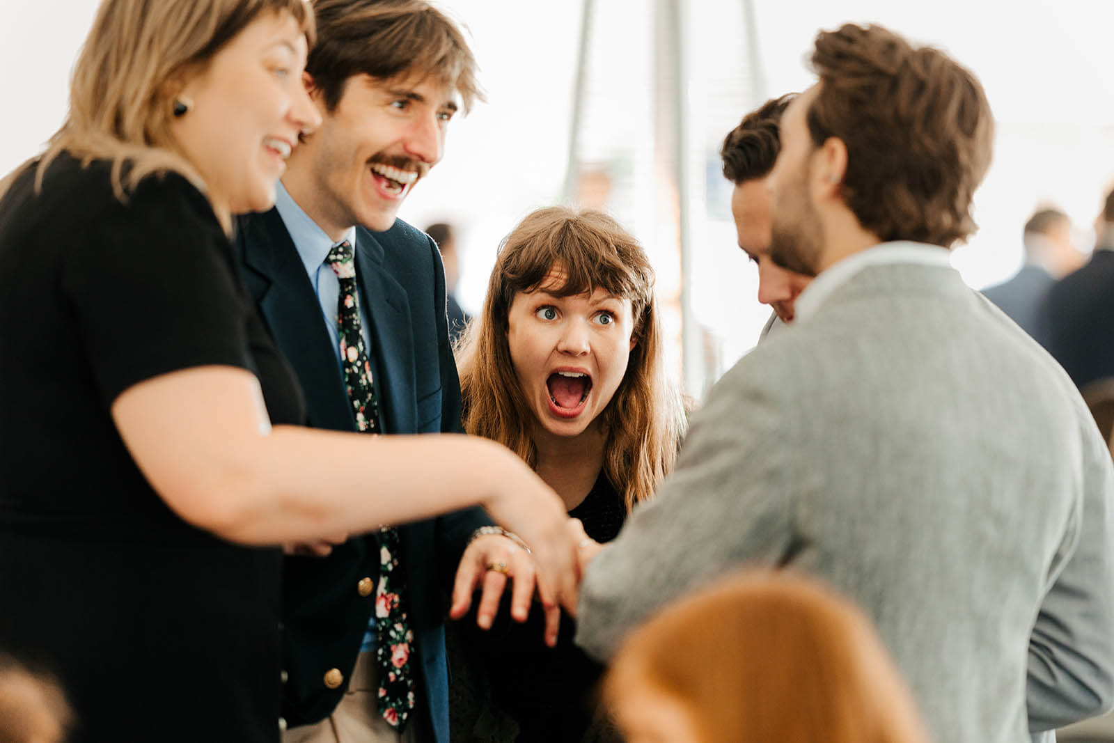 Jamesport Brewing Company wedding photographer Ludington Michigan candid wedding guests reacting with shock and laughter during cocktail hour, best documentary West Michigan wedding photography