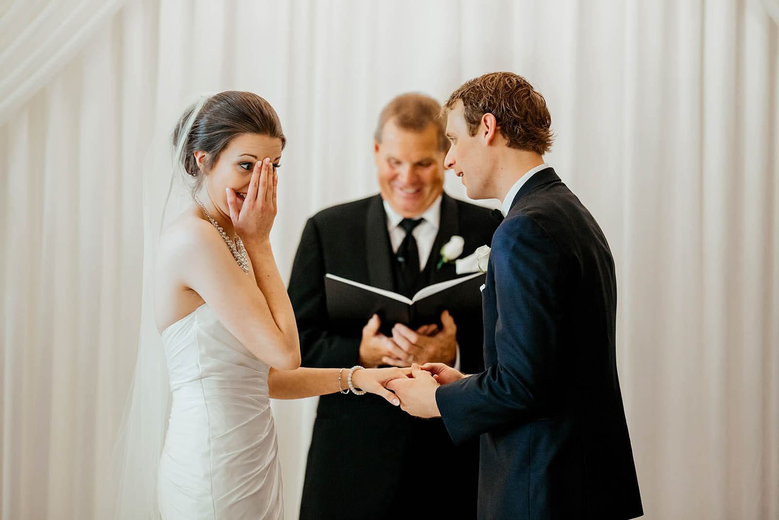 Henry Ford Museum Lovett Hall wedding photographer Detroit Michigan candid bride wiping tears laughing during emotional ring exchange ceremony, top luxury Detroit wedding photography GAUPERphoto