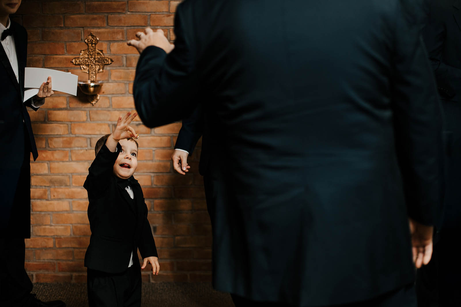 Pipers Banquet Hall wedding photographer Aurora Illinois candid ring bearer in tiny tuxedo reaching up during wedding ceremony, best Illinois documentary wedding photography GAUPERphoto