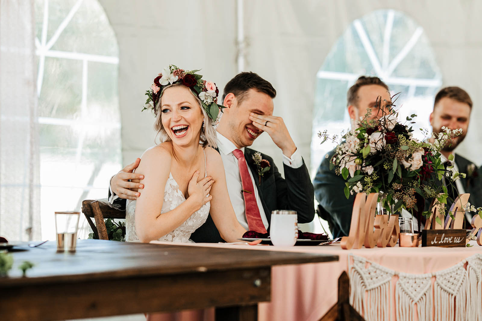 Documentary wedding photographer Indiana candid bride and groom laughing hysterically during speeches at outdoor tented reception, best Indiana editorial wedding photography GAUPERphoto