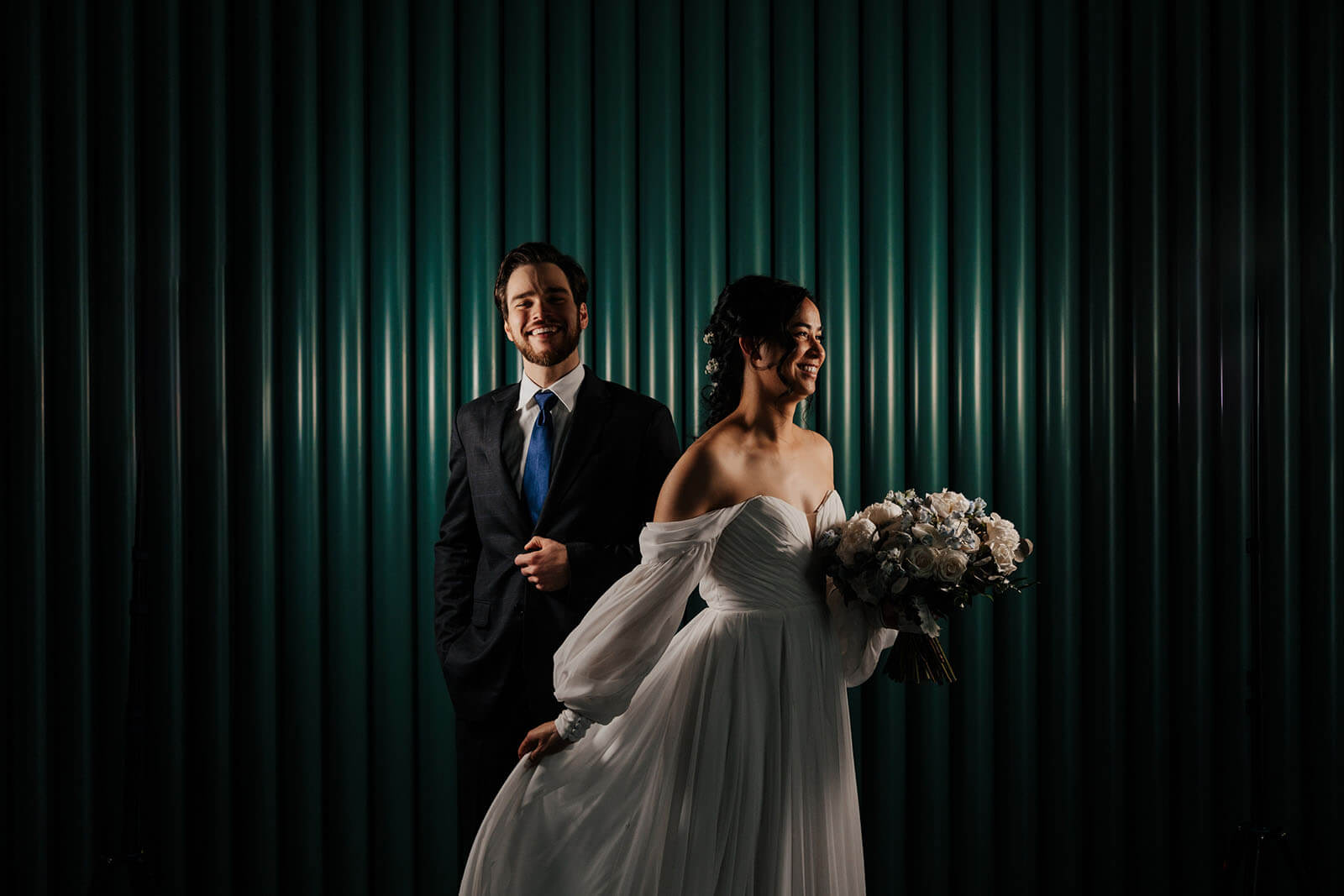 Editorial bride and groom portrait against teal backdrop at Leona Road wedding in Grand Rapids Michigan
