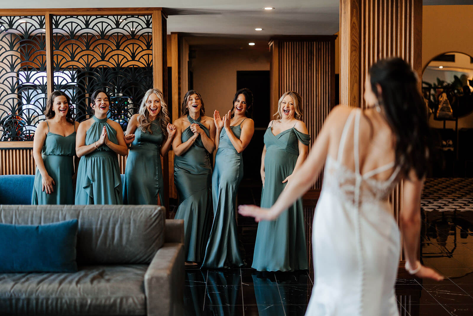 Bridesmaids in teal dresses during first look at Elevate One Campus Martius wedding in downtown Detroit Michigan
