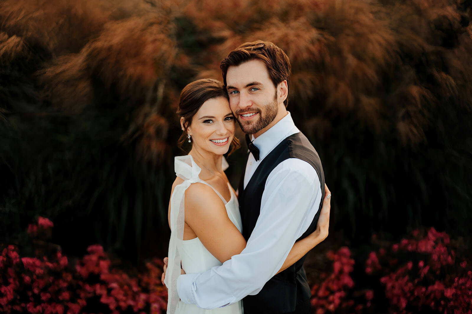 Bride and groom embrace in ornamental grass during golden hour at Timberlee Hills wedding in Traverse City Michigan