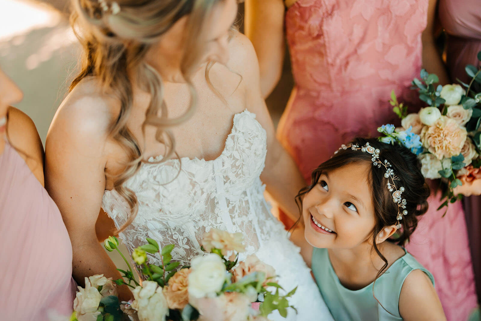 Flower girl looking up at bride wearing floral crown at Timberlee Hills wedding in Traverse City Michigan