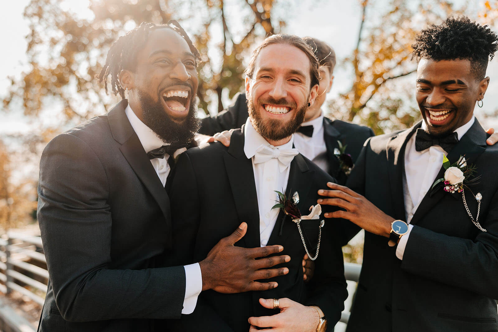 Same sex couple in tuxedos with golden sunburst art at JW Marriott wedding in Grand Rapids Michigan