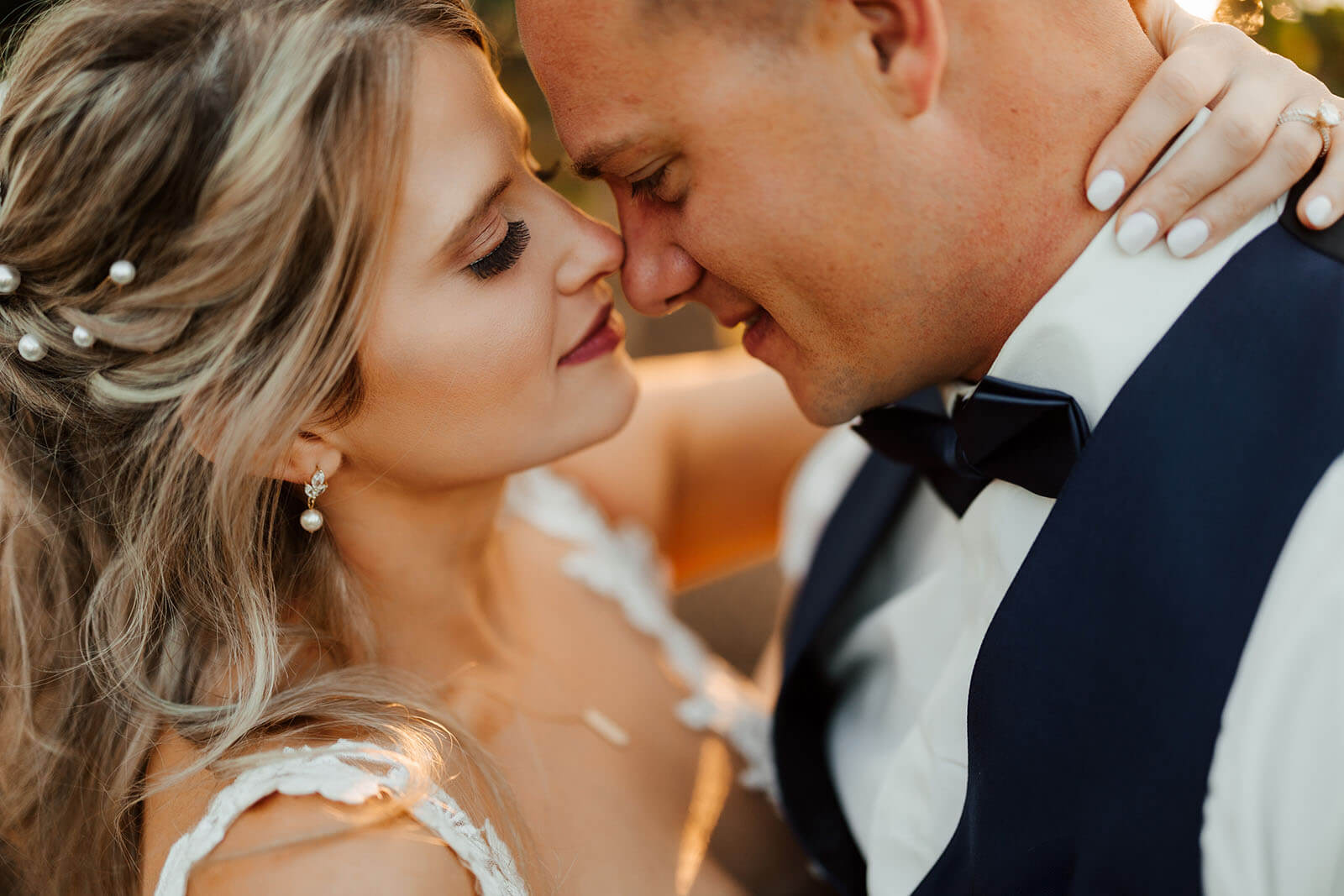 Bride in blush gown by window in moody light at Sojourn Lakeside Resort wedding in Gaylord Michigan