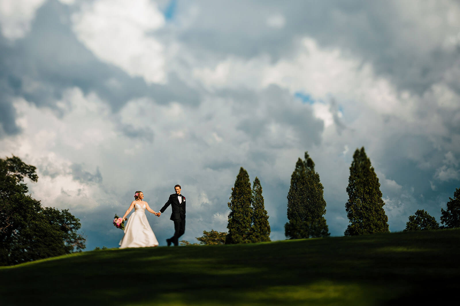 Bride leading dance floor with arms raised at Carriage Greens Country Club wedding in Darien Illinois