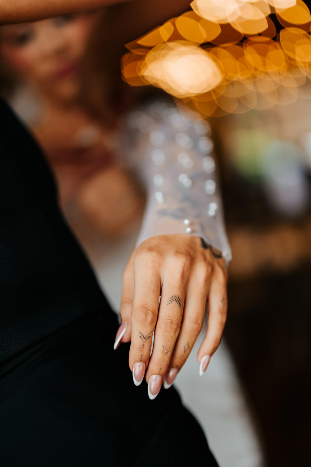Close-up of bride's engagement ring with warm bokeh background