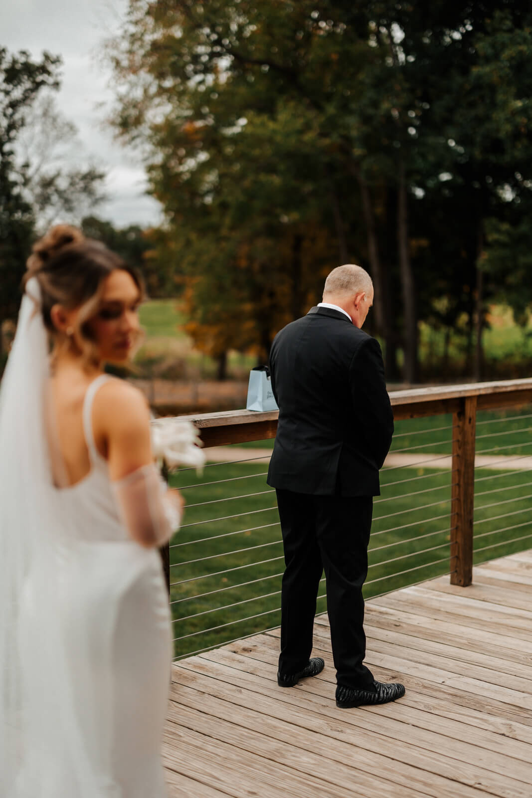 Father waiting with back turned for first look with bride at outdoor winery wedding