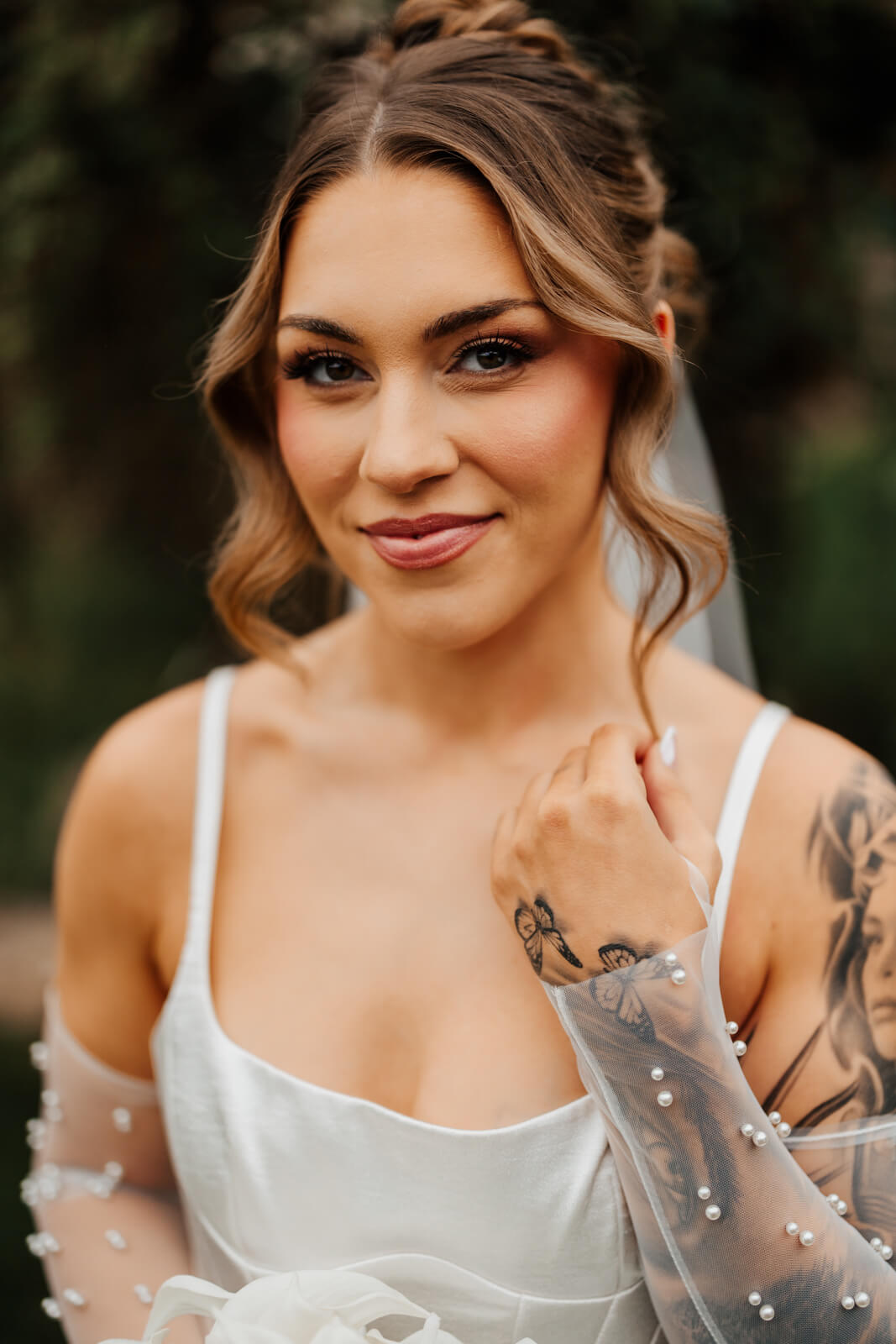 Close portrait of tattooed bride with pearl-dotted veil at fall Michigan winery wedding