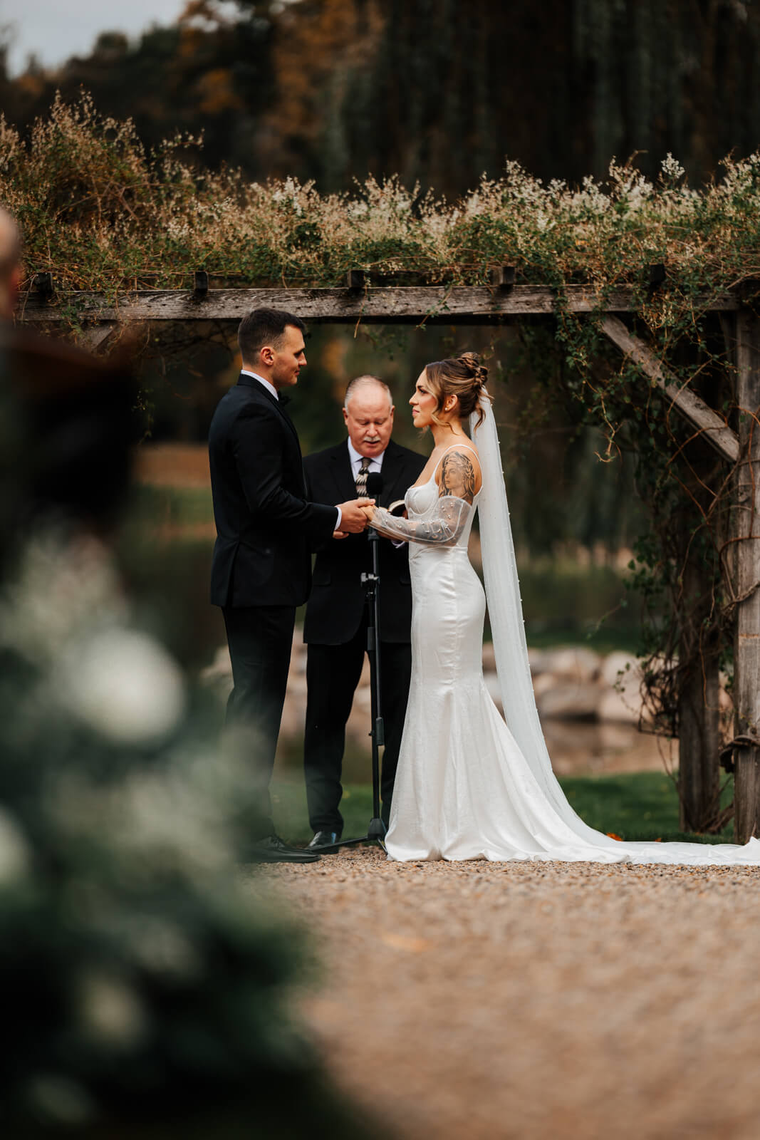 Bride and groom at altar under wooden arch at Westers Family Winery