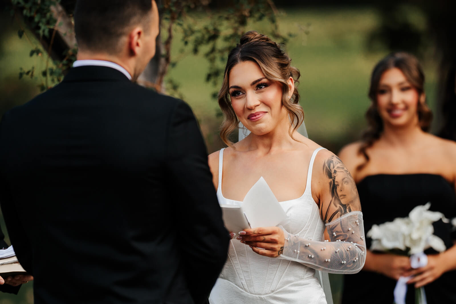 Bride reading wedding vows with emotion during outdoor fall ceremony