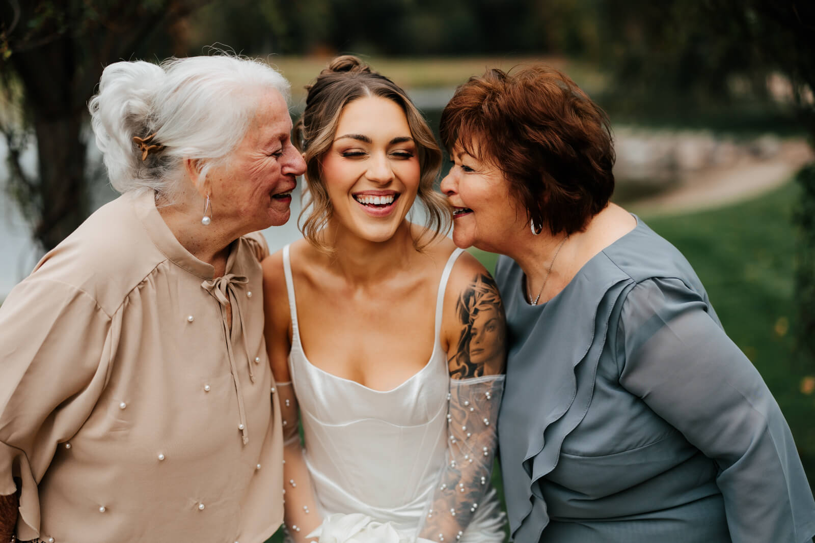 Degrenia wedding - bride being kissed on both cheeks by two grandmothers all three laughing