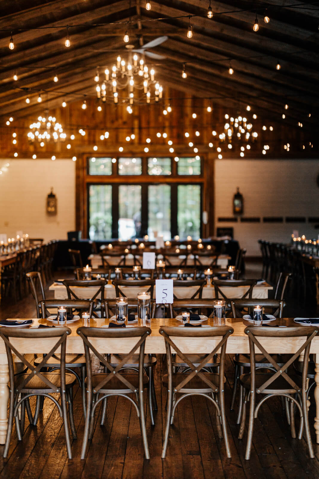 Wedding reception room with string lights and cross-back chairs at Westers Family Winery Junction Michigan