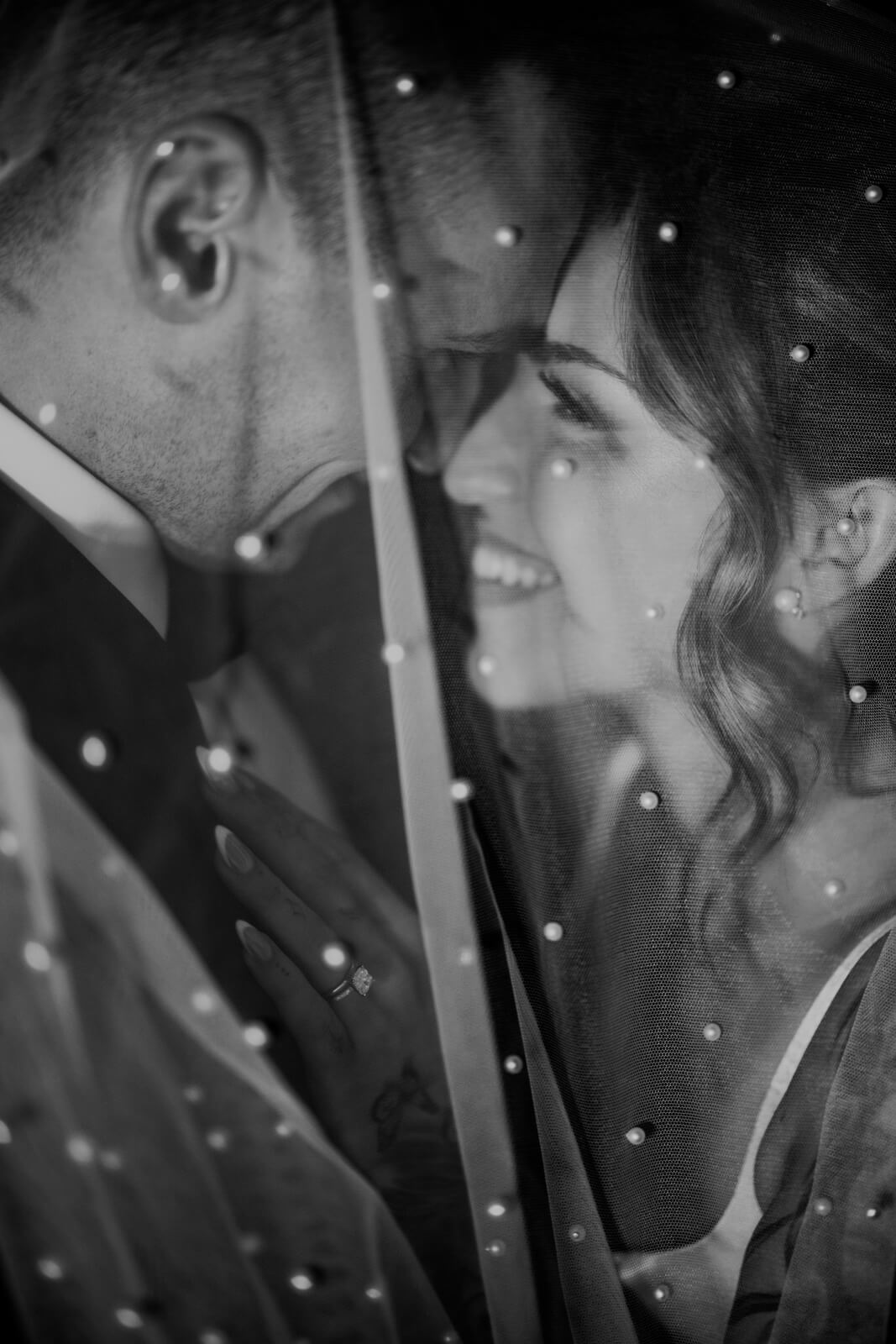 Black and white under-veil portrait of bride and groom close together at Michigan winery wedding