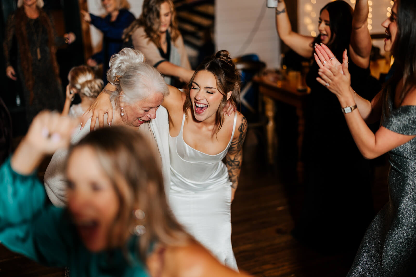 Bride dancing joyfully with older female guest at Westers Family Winery wedding reception