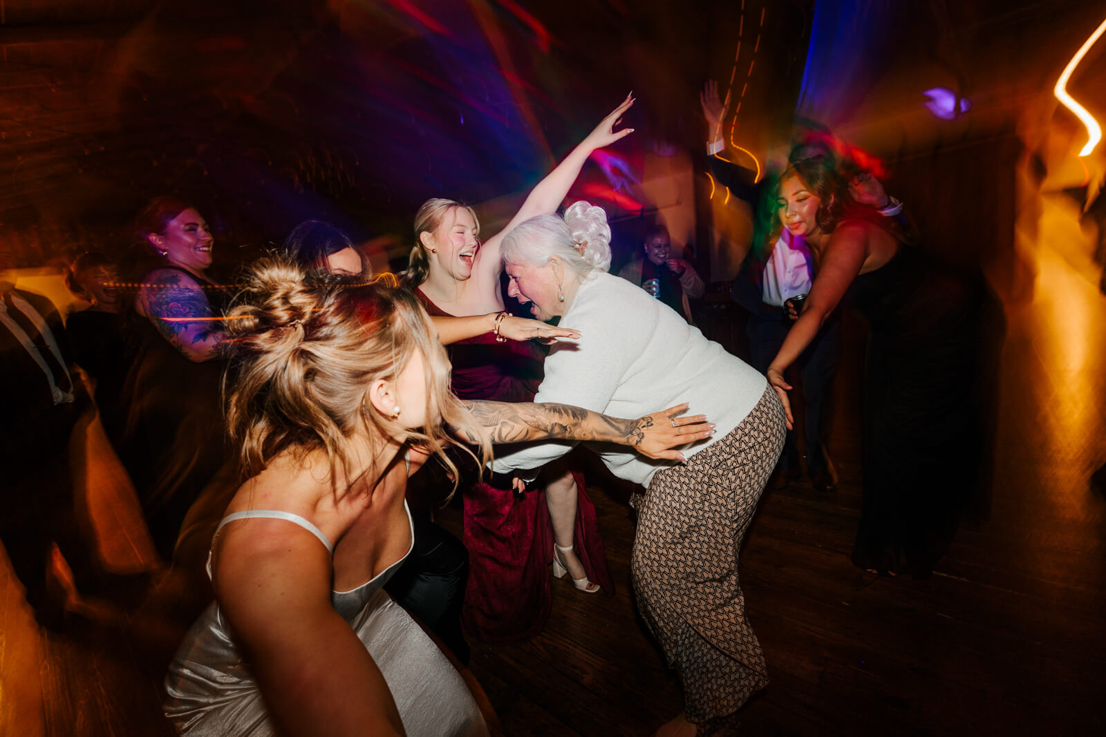Wedding guests dancing under colorful lights at Westers Family Winery fall reception