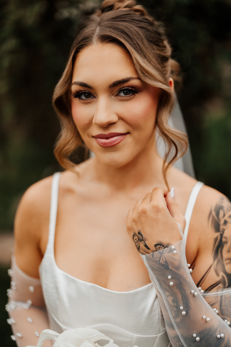 Grand Rapids wedding photographer portrait of tattooed bride with pearl veil and updo